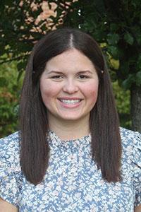 woman with dark brown hair wearing a floral blouse